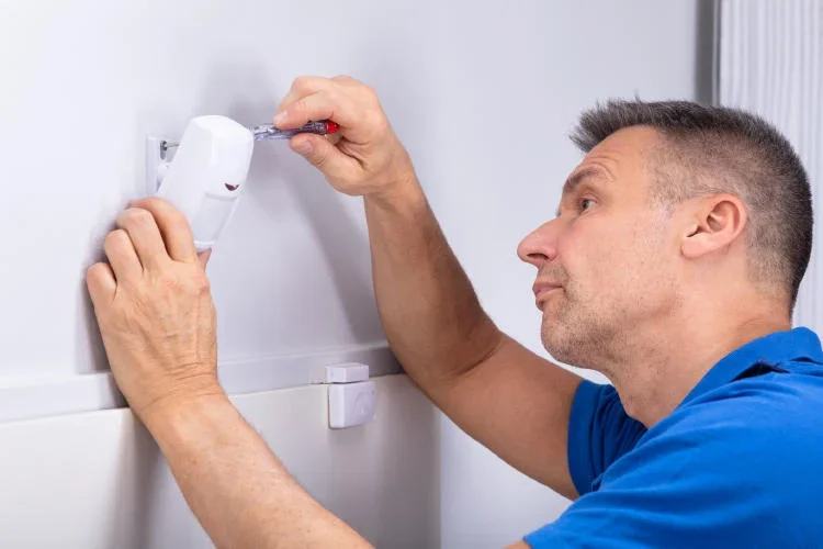 Profesional instalando una alarma de seguridad